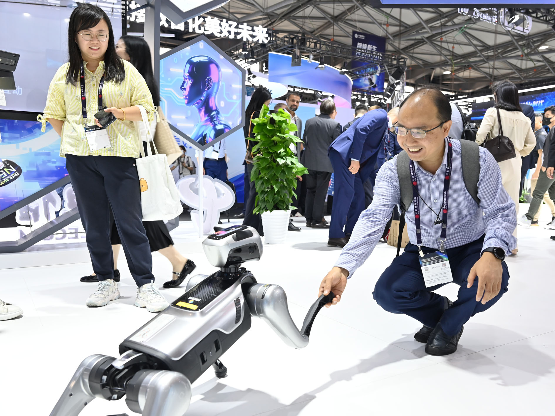 6月18日，观众在2025年世界移动通信大会（上海）中国电信展台与智能机器狗互动。记者 陈爱平 摄