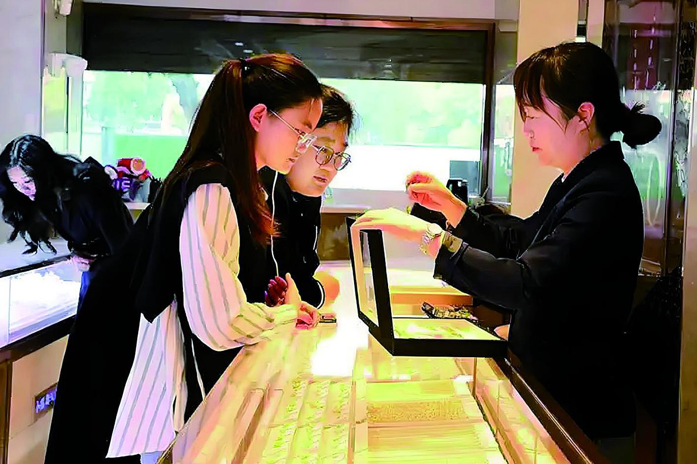 消费者在金店挑选黄金首饰 新华社发