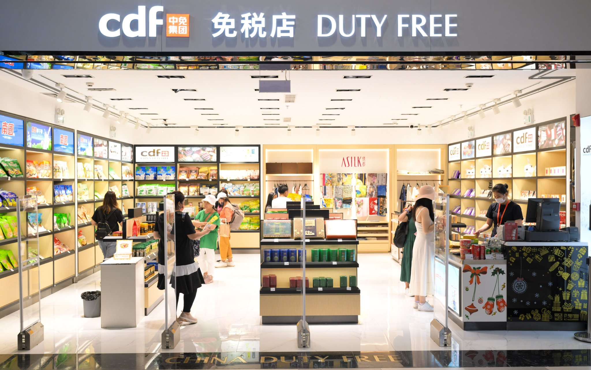 旅客在三亚凤凰国际机场国际航站楼内的免税店选购商品。 新华社记者 杨冠宇 摄