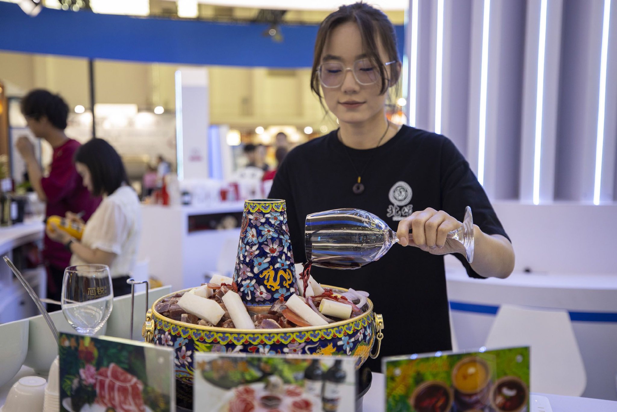 近日，在第五届中国（宁夏）国际葡萄酒文化旅游博览会上，一家参展商的工作人员在烹饪红酒涮肉。新华社记者 杨植森 摄